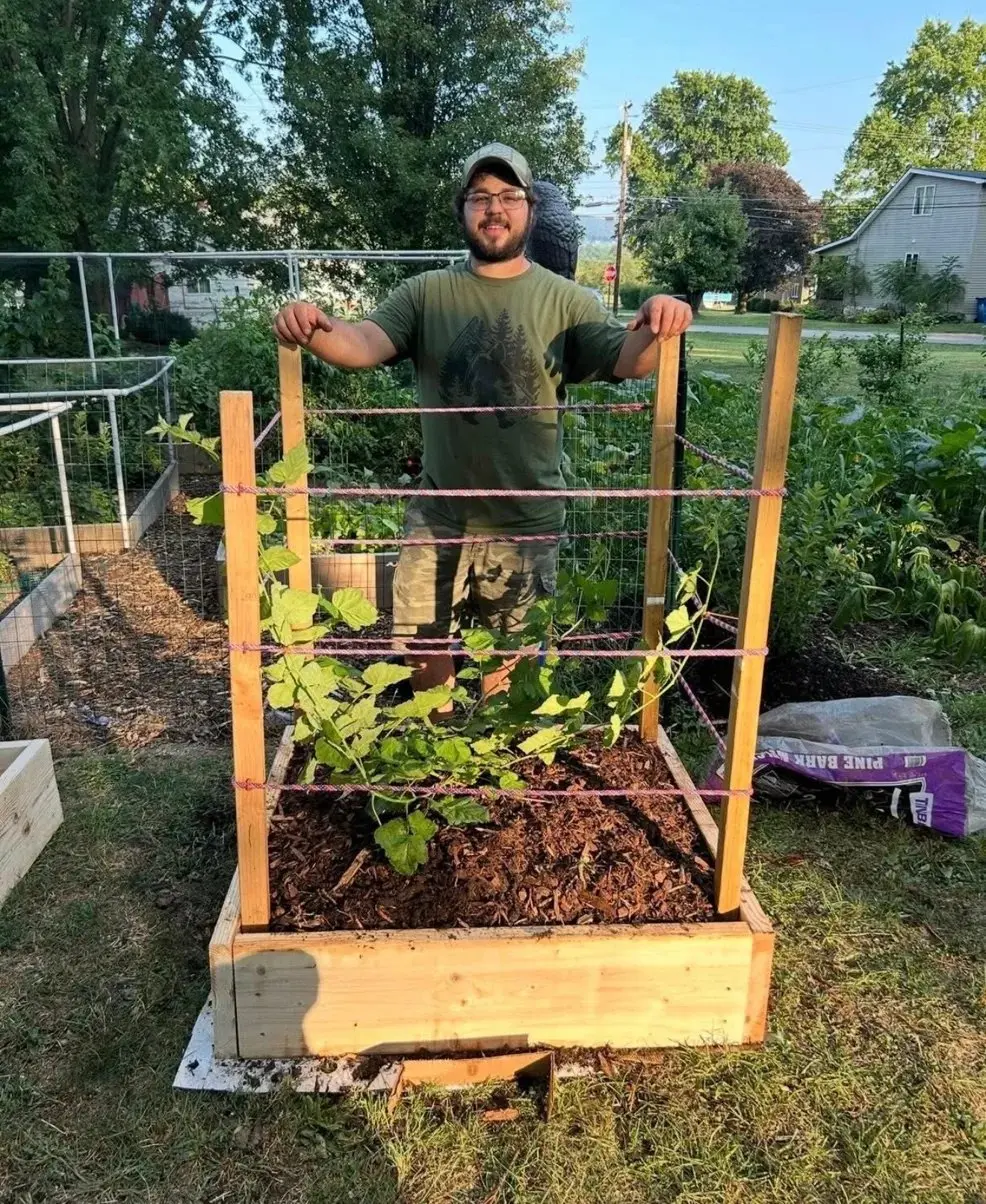 Tyler Mullen tending organic berry plants and fruit trees at The Sanctuberry backyard garden in Latrobe, Pennsylvania